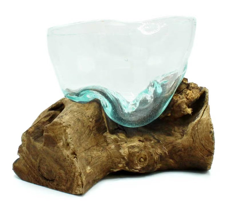 Glass bowl with wavy design on a wooden base against a white background