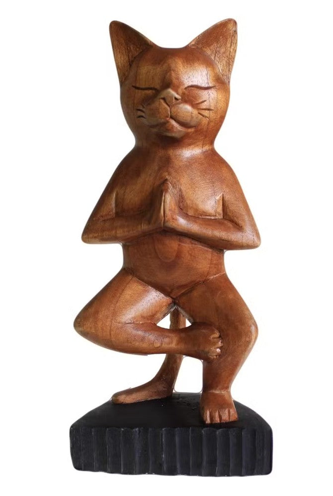 Wooden cat figurine in a yoga pose on a white background